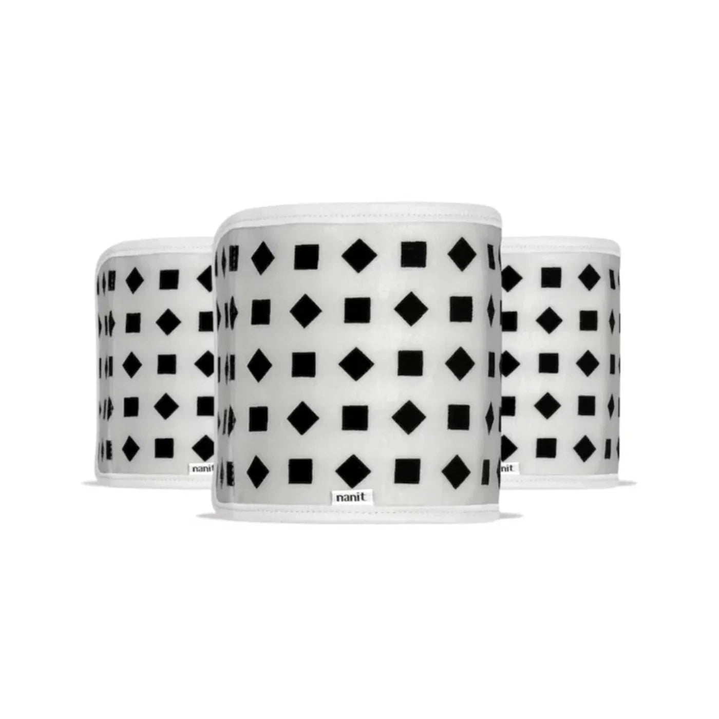 Nanit Breathing Wear Band for babies, small size, soft fabric, designed for breathing motion monitoring, shown with camera in the background.